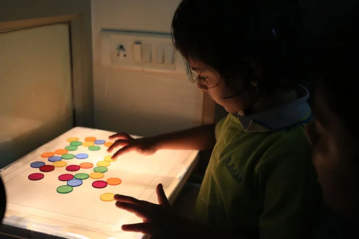 Nursery child at a light table at Edistää Preschool, Wadala West, Mumbai