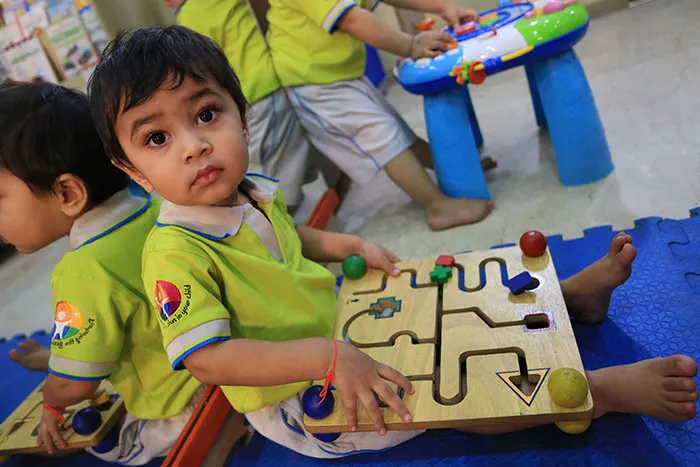 Toddler playing with a wooden maze board at Edistää Preschool, Wadala West, Mumbai